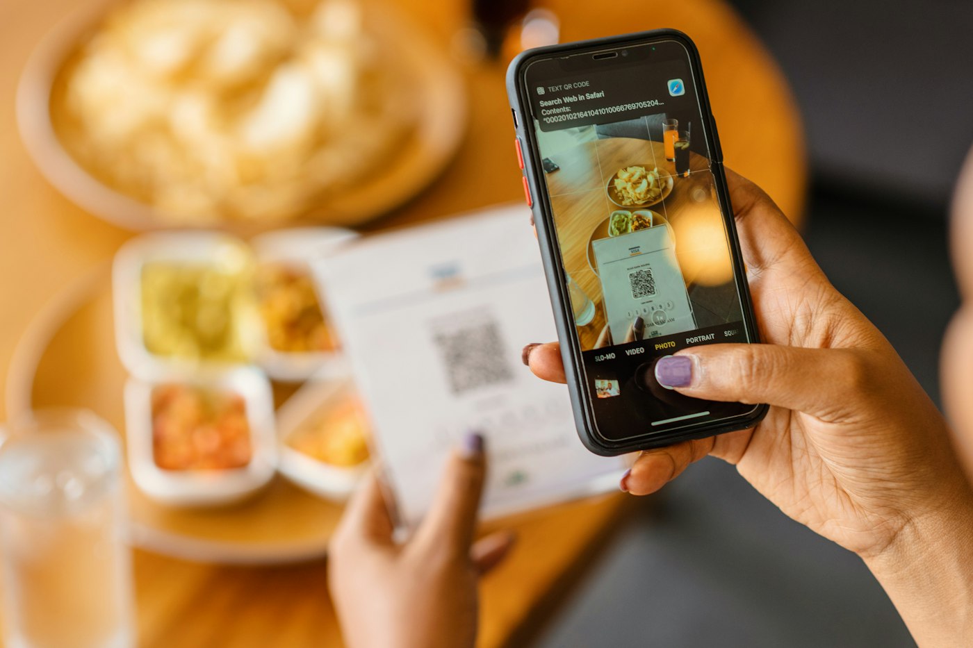 Un cliente inquadra con il telefono il QR code del menu sul tavolo