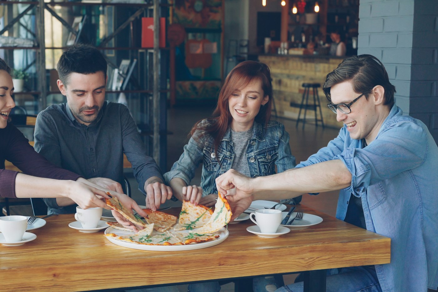 Friends sharing a pizza at a pizzeria table