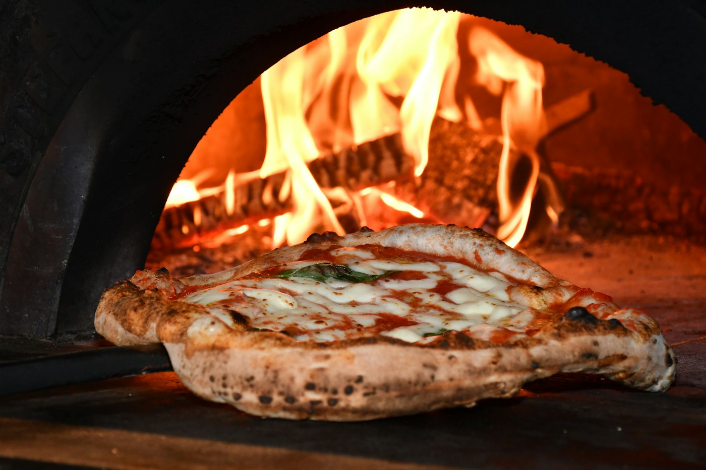 A Margherita baking in a wood-fired oven